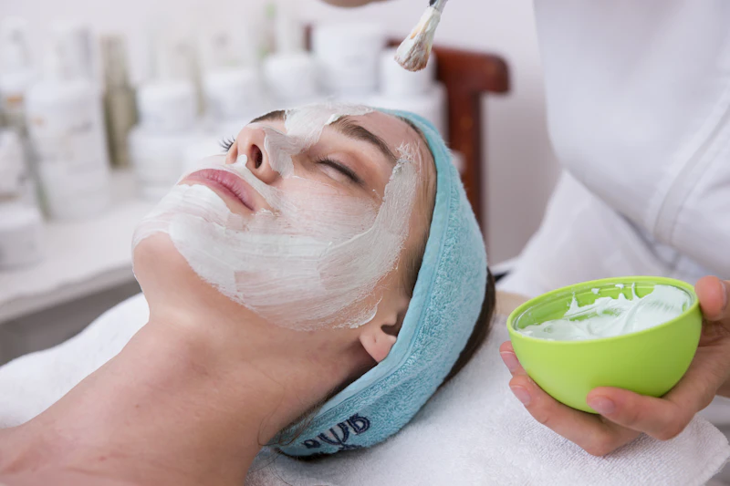 Close view of hands during a gentle skincare application, evoking a facial treatment.
