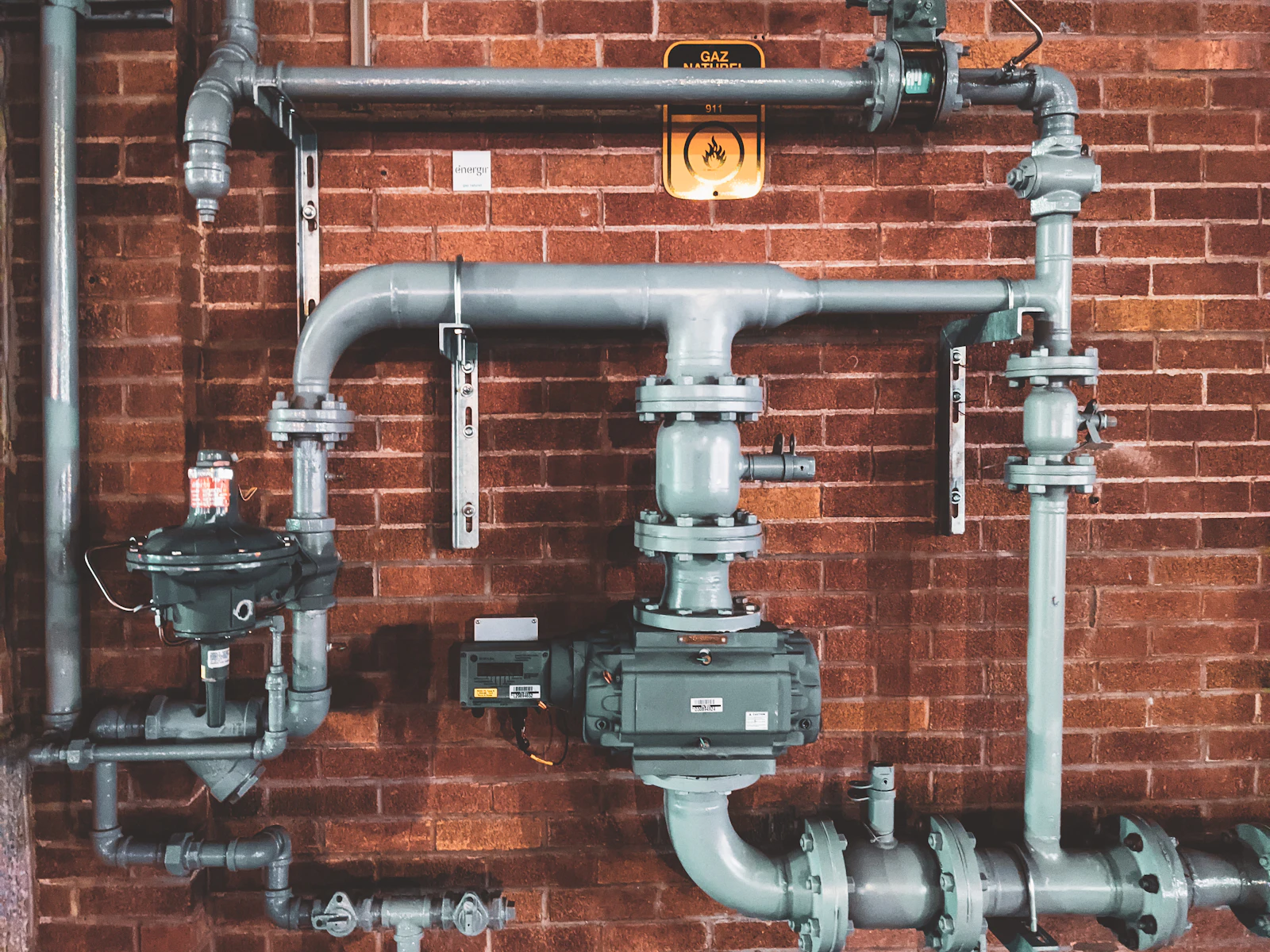 Licensed plumber in branded workwear repairing pipework in a modern Australian home