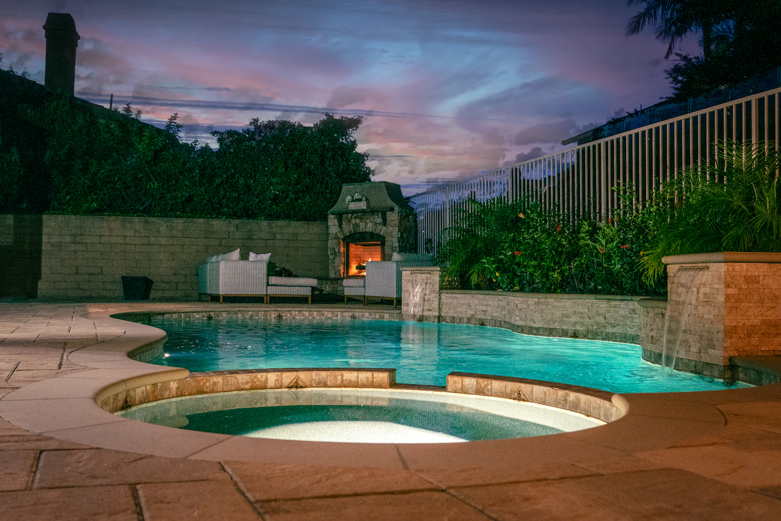 Landscaped Gold Coast backyard with an in-ground pool surrounded by established trees and lawn in afternoon light